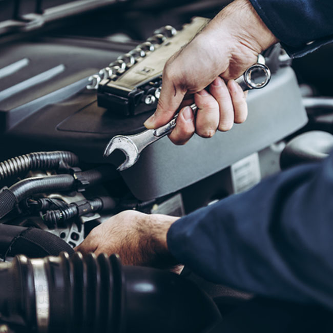 Auto repairman fixes a car's engine.