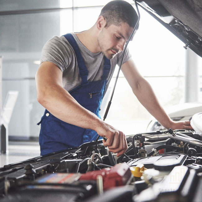 A mechanic fixing a car. This can be shown in your auto repair ads.